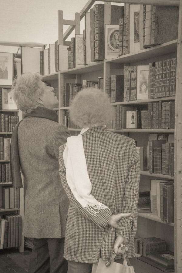 Two people browsing books at an outdoor market